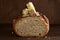 Artisan sourdough bread with butter and pink himalayan salt on dark wooden background