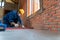 Artisan tiler hands working on a new house entrance, local and professional handyman applying tiles at construction site