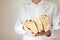 Artisan traditional bread Ciabatta in the hands of a young man on a light background.