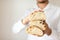 Artisan traditional bread Ciabatta in the hands of a young man on a light background.