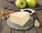 Artisanal Canastra cheese from Brazil over wooden board with nuts, jam and green apples