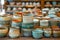 Artisanal Pottery Collection Displayed on Wooden Shelves Featuring Colorful Ceramic Bowls and Handcrafted Vessels in Various