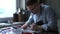 Artist in apron in studio making linocut using instrument
