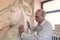 Artist in the art studio at work on a sculpture of large clay horse head