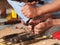 Artist carving wooden BUDDHA figure with primitive self-made tools and small hammer