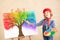 Artist child painting the rainbow on canvas