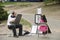 Artist draftsman drawing portrait of a young girl in Central Park, NYC