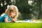 Artist kids. Kid draws in park laying in grass having fun on nature background.