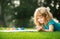 Artist kids. Kid draws in park laying in grass having fun on nature background.