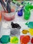 Artist paint brushes in white bucket of water, acrylic colour in plastic cups in art studio