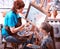 Artist painting easel in studio. Authentic grandmother and kids.