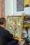 The artist paints a Buddhist icon