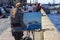 The artist paints a landscape on the Neva Embankment in St. Petersburg. A woman drawing a picture on the street