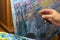 An artist with a palette paints with a palette knife close-up