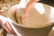 Artist potter in the workshop sculpting ceramic vase