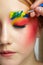 Artist`s hand with paintbrush painting beautiful teen girl`s brows make-up