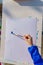 Artist`s work place. A kid paints with blue gouache a picture. Open air workshop