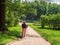 Artist view from back, woman draws a picture, summer green park with pond, creating creativity artistic mood