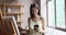 Artist woman distracted from painting to answer on sms