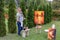 Artist woman holds painting and looks at it, posing at camera an