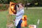 Artist woman holds painting and looks at it, posing at camera an