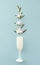 Artistic arrangement made of white tropic flowers and champagne glass on blue background. Minimal summer party or celebration