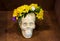 Artistic atmosphere: vase with colored water, creative mood, skull in flowers wreath.