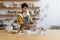 Artistic ceramist girl master at work: happy woman in apron holding handmade jug in ceramics studio