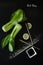 Artistic composition of Asian Food Products - Bok Choy , soy sauce, lemon end sesame seeds on a black background