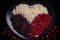 Artistic and creative macro shot of red beans and rice arranged in a heart shape on a black plate
