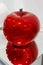 Artistic Depiction of Red Apple made of Colored and Brilliant Glass Reflecting on the Mirrored supporting Surface