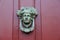 Artistic detail in elaborate knocker on red door of home