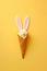 Artistic Easter Bunny Ice Cream Cone Sculpture on Yellow isolated Background. Copy space post card