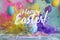 An artistic explosion of color frames the festive greeting Happy Easter, capturing the vibrant essence of the holiday.