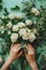 Artistic Hands Arranging a Bouquet of Elegant White Roses.