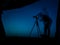 Artistic long exposure photo of a photographer in action. Multiple silhouettes and a camera un tripod.