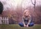 Artistic outdoor portrait of a cute blond girl holding on to a fence