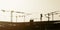 Artistic panorama view silhouette group of tower cranes working on construction site.