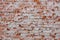 artistic red brick background in grunge or retro style from old wall with signs of wear and cement mortar remains for creative