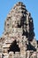 Artistic stone human faces embellishing the towers of the Khmer Bayon Temple in Cambodia