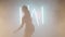 Artistic young woman dancing in backlit fog smoke indoors. Confident graceful Caucasian female dancer rehearsing modern