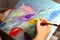 Artists hand with paintbrush painting the picture