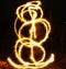 Artists juggling with two flaming poi\'s on fire. Prolonged exposure causes painting with light.