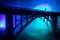 Artwork decoration. Silhouette of powerful metallic bridge at night with foggy backlight. Silhouette of person standing on bridge