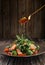 Arugula and mini spinach salad with slices of salmon in sesame seeds, with segments of red oranges and sweet, orange sauce