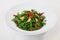 Arugula salad dried tomatoes parmesan top circular plate white background