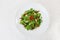 Arugula salad dried tomatoes parmesan top circular plate white background isolated