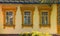 Ð¡arved wooden platbands on three yellow windows of traditional Ukrainian village house.