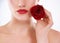 As delicate as a rose. Cropped studio shot of a woman holding a rose next to the lower half of her face.