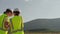 As energy researchers, two women engineers analyze and compare data on a clean wind farm with confidence on a wind farm